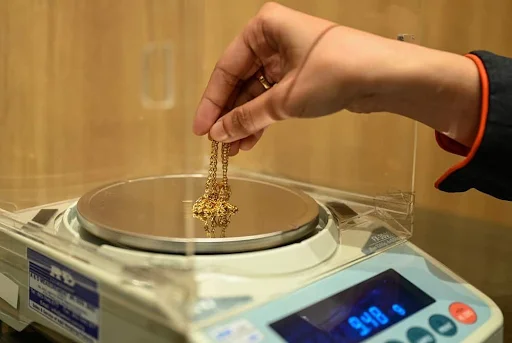 Gold chain being weighed on a digital scale