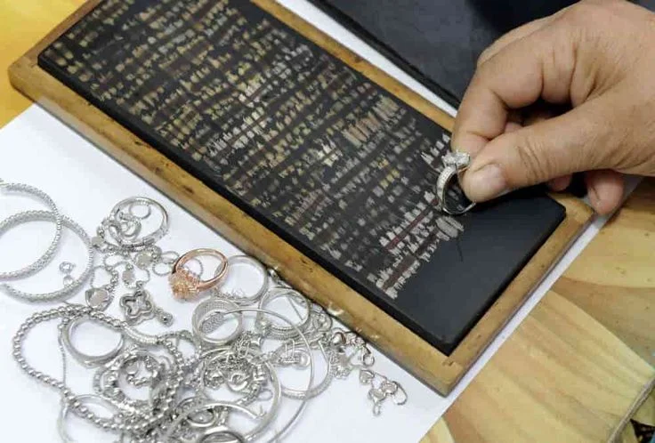 Jewelry being assessed on a black testing slate